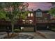 Townhome exterior featuring brick, balconies, and garages, framed by lush greenery and a dramatic sunset at 75 High Top Ln, Atlanta, GA 30328