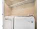 Modern laundry room with white front-loading washer and dryer, and wire shelving above at 75 High Top Ln, Atlanta, GA 30328
