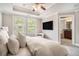 Bright main bedroom features a tray ceiling, a wall-mounted TV, and large windows, creating a relaxing space at 75 High Top Ln, Atlanta, GA 30328