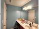 Bathroom featuring a large mirror over a vanity with a stool and neutral blue walls at 1117 Balvaird Dr, Lawrenceville, GA 30045