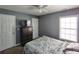 Bedroom featuring neutral gray walls, a window, and a TV on a dark wooden dresser at 1117 Balvaird Dr, Lawrenceville, GA 30045