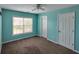 Bedroom with light-blue painted walls, ceiling fan, window, and carpet at 1117 Balvaird Dr, Lawrenceville, GA 30045