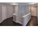 Hallway with wood floors, staircase with white banister, and white doors at 1117 Balvaird Dr, Lawrenceville, GA 30045