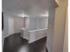 Hallway with wood floors, staircase with white banister, and white doors at 1117 Balvaird Dr, Lawrenceville, GA 30045
