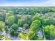 High-angle view of a neighborhood with tree-lined streets and homes nestled within green foliage at 118 Greenwood St, Fairburn, GA 30213