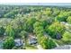 An aerial shot showing the home and its spacious, tree-filled lot in a suburban neighborhood at 118 Greenwood St, Fairburn, GA 30213