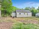 Backyard showcasing the home's exterior, patio area, and spacious lawn surrounded by mature trees at 118 Greenwood St, Fairburn, GA 30213