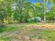 Expansive backyard featuring mature trees, a partially cleared lot, and natural landscape at 118 Greenwood St, Fairburn, GA 30213