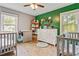 Bedroom with two cribs, refinished hardwood floors, neutral paint, and large windows for plenty of light at 118 Greenwood St, Fairburn, GA 30213