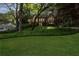 Beautiful home nestled among mature trees featuring a lush green lawn and attractive landscaping at 375 Spindle Ct, Sandy Springs, GA 30350