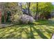 Well-manicured front yard with a vibrant green lawn, mature trees and flowering shrubs for added curb appeal at 375 Spindle Ct, Sandy Springs, GA 30350