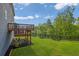 Backyard view featuring a wooden deck, lush lawn and privacy fence surrounded by mature trees at 186 Greenbrier Way, Canton, GA 30114