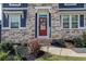 Charming front entrance with stone accents, a bright red door, and well-manicured landscaping at 186 Greenbrier Way, Canton, GA 30114