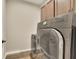 Modern laundry room with gray front-loading washer and dryer and storage cabinets at 186 Greenbrier Way, Canton, GA 30114