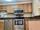Galley kitchen featuring stainless steel appliances, granite countertops and wood cabinets at 199 14Th Ne St # 710, Atlanta, GA 30309