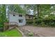 Exterior home view highlighting the two-car driveway, a front deck, and lush foliage at 2551 Park Se Rd, Smyrna, GA 30080