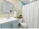 Charming bathroom with wood accent wall, modern vanity, and white shower curtain at 428 Tibbetts Se St, Marietta, GA 30060