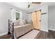 Serene bedroom with a trundle bed, hardwood floors, and sliding barn door at 428 Tibbetts Se St, Marietta, GA 30060