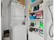 Functional laundry area featuring stacked washer and dryer plus storage shelves at 428 Tibbetts Se St, Marietta, GA 30060