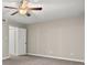 Carpeted bedroom features a ceiling fan, neutral walls, and a glimpse into an adjoining space at 95 Ivy Ne Trl, Atlanta, GA 30342