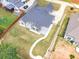 Aerial shot of the brick home with a fenced backyard and a stone seating area with walking path at 953 Auburn Rd, Dacula, GA 30019