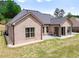 Home's back exterior featuring brick and siding, a well-maintained lawn, and a concrete patio at 953 Auburn Rd, Dacula, GA 30019