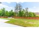 A well-maintained backyard featuring green grass, a wooden fence, and a stone sitting area at 953 Auburn Rd, Dacula, GA 30019