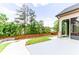 View of a backyard with a concrete patio, stone seating area, walkway, and lush green grass at 953 Auburn Rd, Dacula, GA 30019