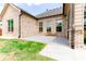 Backyard patio of brick home featuring green grass, a concrete patio, and exterior windows at 953 Auburn Rd, Dacula, GA 30019