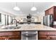 The kitchen features granite countertops, stainless steel appliances, and views of the fireplace at 953 Auburn Rd, Dacula, GA 30019