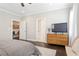 Comfortable bedroom with hardwood floors, TV on dresser, and bench seating at 1085 Celebration Dr, Roswell, GA 30076