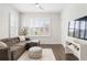Modern living room with a comfortable sofa, large window, and hardwood floors at 1085 Celebration Dr, Roswell, GA 30076