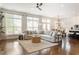 Open-concept living area with a comfortable sofa, large windows, and hardwood flooring at 1085 Celebration Dr, Roswell, GA 30076