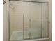 Bathroom with white tile and sliding glass doors enclosing the tub and shower at 115 Plantation Dr, Clarkston, GA 30021