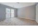 Bright bedroom with sliding glass doors to the backyard and neutral carpet; large window provides plenty of natural light at 115 Plantation Dr, Clarkston, GA 30021