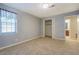A spacious bedroom with neutral carpet and a window with a patterned curtain at 115 Plantation Dr, Clarkston, GA 30021