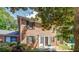 Inviting brick-facade home with black shutters, front lawn, and beautiful mature trees in a well-maintained neighborhood at 115 Plantation Dr, Clarkston, GA 30021