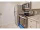 Well-equipped kitchen featuring stainless steel appliances, white cabinetry, granite countertops, and a stylish tile backsplash at 115 Plantation Dr, Clarkston, GA 30021
