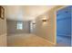 Spacious living room featuring neutral carpet, crown molding, modern sconces, and two windows with charming checkered curtains at 115 Plantation Dr, Clarkston, GA 30021