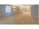 Open-concept living room with neutral carpeting, featuring an entry to the dining area with bright natural light at 115 Plantation Dr, Clarkston, GA 30021