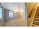 Bright and spacious living room featuring neutral carpeting, staircase and decorative lighting fixtures at 115 Plantation Dr, Clarkston, GA 30021