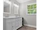 Bright bathroom features a double vanity with framed mirrors and a window at 4524 Shumart Dr, Snellville, GA 30039