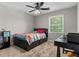 Cozy bedroom features a colorful bedspread, a dark desk, and a window at 4524 Shumart Dr, Snellville, GA 30039
