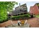 Exterior view of a multi-story deck, lush backyard, landscaping, and firepit sitting area at 4674 Lakeway Pl, Alpharetta, GA 30005