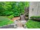 Exterior view of a backyard featuring landscaping, multiple levels, stairs, and wooded view at 4674 Lakeway Pl, Alpharetta, GA 30005
