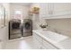 A well equipped laundry room with front load washer and dryer and a deep utility sink at 4674 Lakeway Pl, Alpharetta, GA 30005
