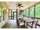 Charming screened porch with dining table and seating, ceiling fan, and serene wooded surroundings at 4674 Lakeway Pl, Alpharetta, GA 30005
