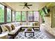 Cozy screened porch with comfortable sectional seating, ceiling fan, TV, and wooded views at 4674 Lakeway Pl, Alpharetta, GA 30005