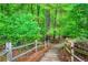 Wooded path leading through a lush green forest with a rustic fence at 4674 Lakeway Pl, Alpharetta, GA 30005