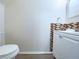 Simple bathroom featuring a toilet and vanity with brown tiled backsplash at 1812 Ashborough Se Cir # C, Marietta, GA 30067